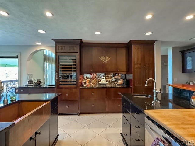 kitchen with wine cooler, sink, butcher block countertops, and dark brown cabinetry