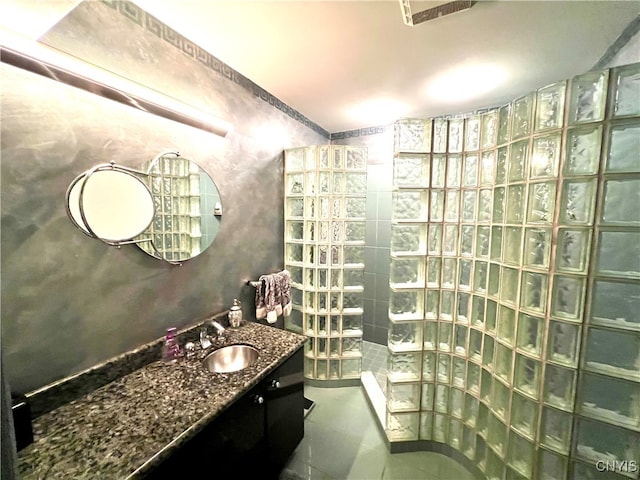 bathroom with vanity, a shower, and tile patterned floors