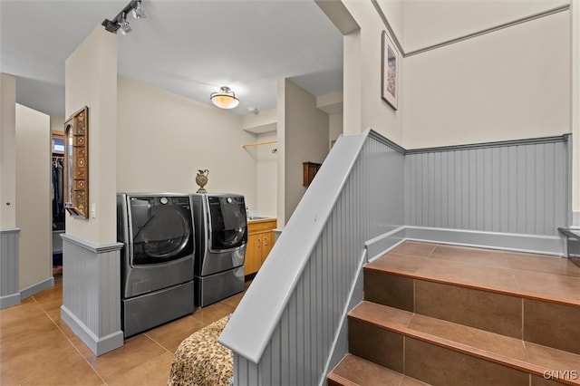 staircase featuring independent washer and dryer, track lighting, and tile patterned floors