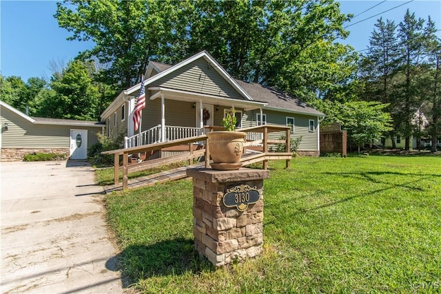 bungalow-style home featuring covered porch and a front lawn