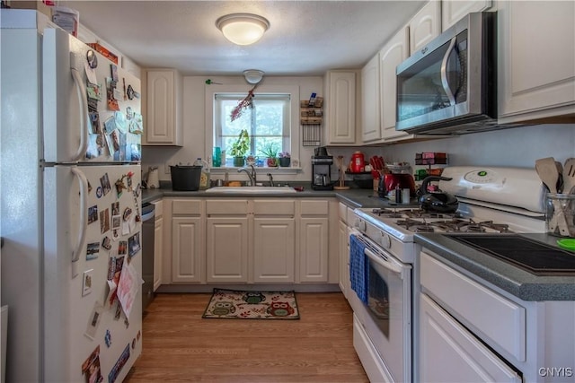 kitchen featuring white cabinetry, appliances with stainless steel finishes, sink, and light hardwood / wood-style floors