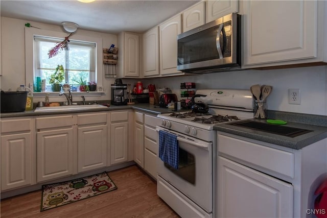 kitchen with white cabinetry, sink, white gas stove, and light wood-type flooring