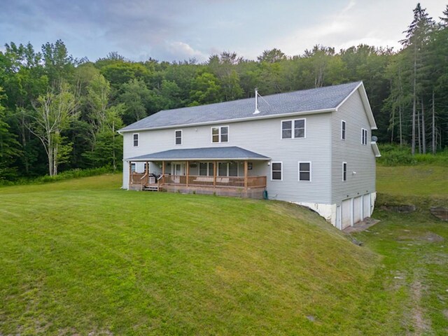 1724 Calhoun Hill Rd, Andes, NY 13731 - back of house with a wooded view, a garage, a yard, and covered porch