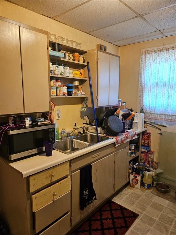 kitchen featuring light tile patterned floors, sink, and a drop ceiling