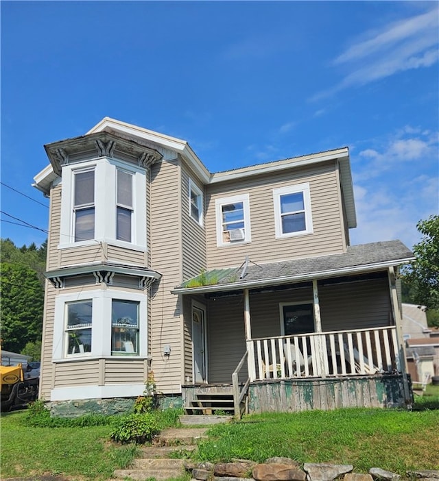 view of front of property with covered porch and a front lawn