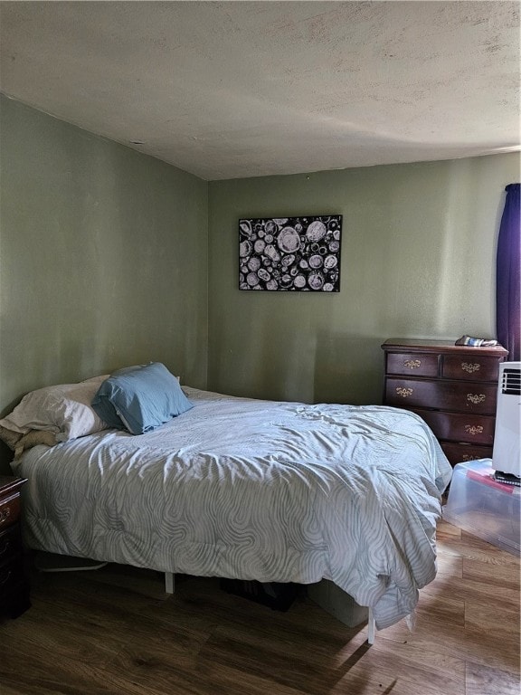 bedroom featuring a textured ceiling and hardwood / wood-style floors