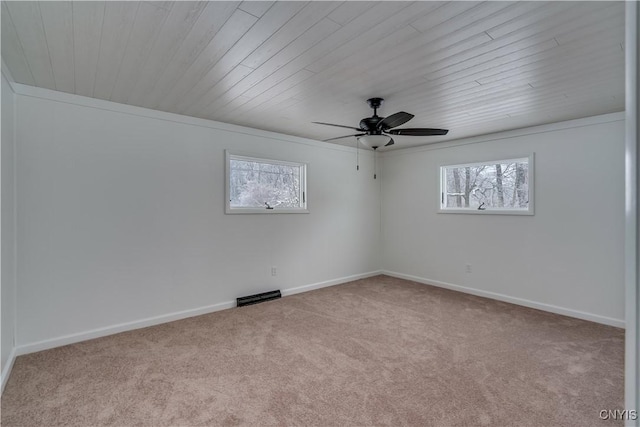 spare room featuring baseboards, a ceiling fan, visible vents, and light colored carpet