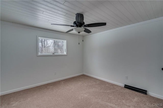 carpeted spare room featuring a ceiling fan, visible vents, and baseboards