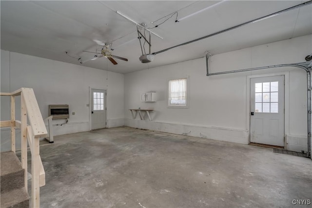 garage with a garage door opener, heating unit, and a ceiling fan