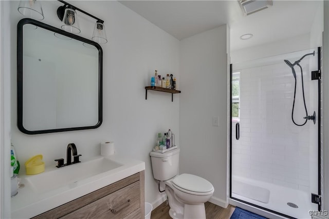 full bath with toilet, wood finished floors, visible vents, vanity, and a stall shower