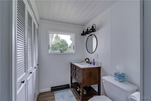 bathroom featuring toilet, wood ceiling, wood finished floors, vanity, and a closet