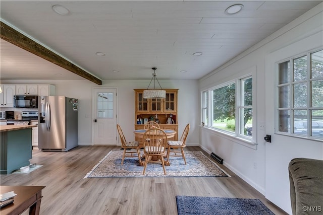 dining area with light wood finished floors, beam ceiling, and baseboards