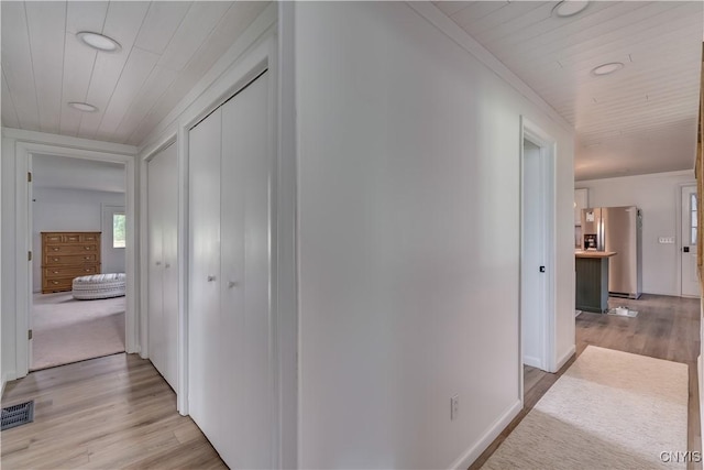 hall with wood ceiling, visible vents, and light wood-style flooring