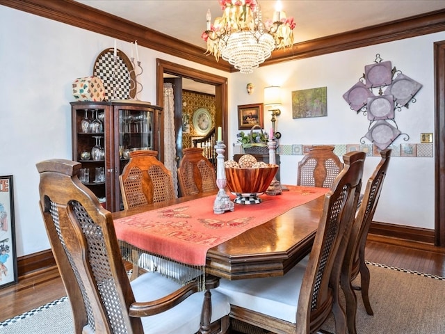 dining space featuring ornamental molding, hardwood / wood-style floors, and an inviting chandelier