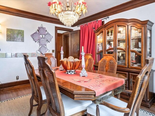 dining room with a notable chandelier, ornamental molding, and hardwood / wood-style flooring