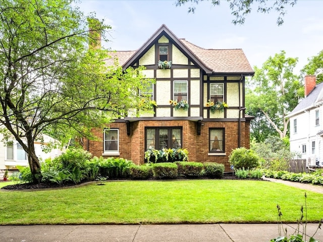 tudor home featuring a front yard