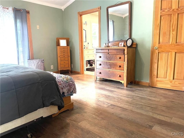 bedroom with ensuite bath, crown molding, baseboards, and wood finished floors