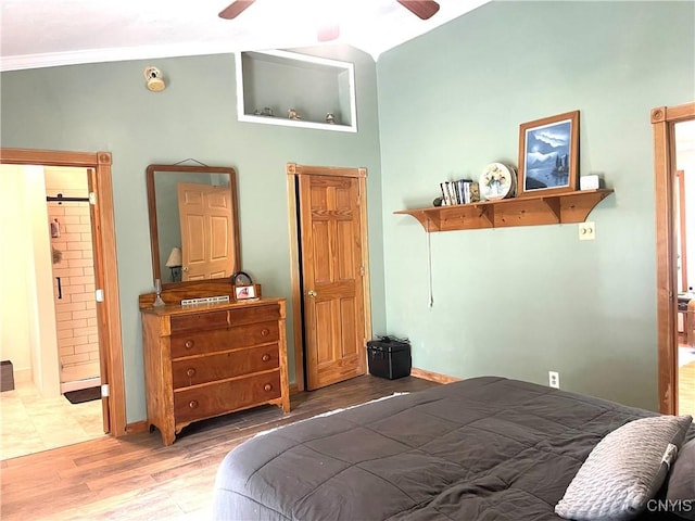 bedroom with baseboards, a ceiling fan, wood finished floors, and ensuite bathroom