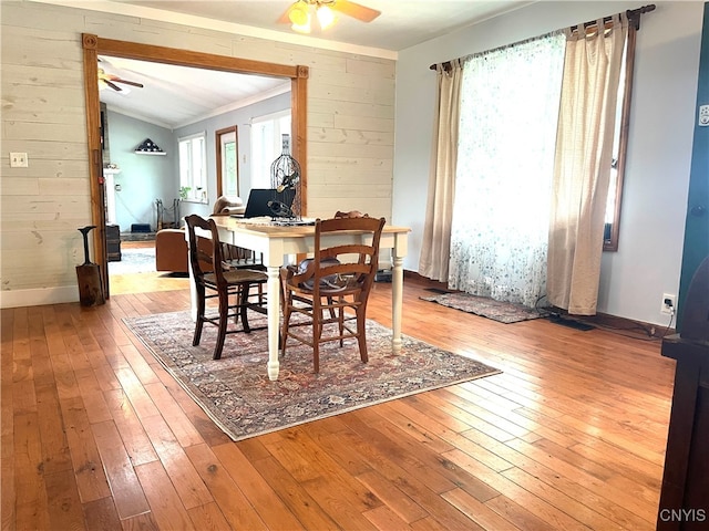 dining space featuring ceiling fan, light wood-type flooring, and vaulted ceiling