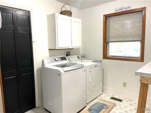 washroom featuring light tile patterned flooring, washing machine and clothes dryer, and cabinets