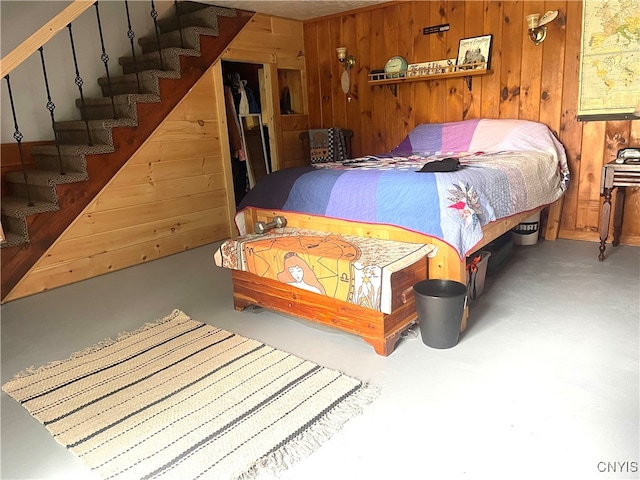 bedroom featuring wooden walls