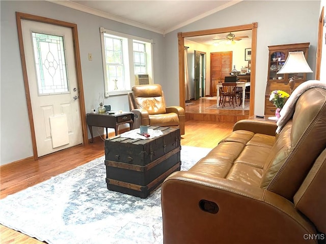 living room with a ceiling fan, crown molding, lofted ceiling, and wood finished floors