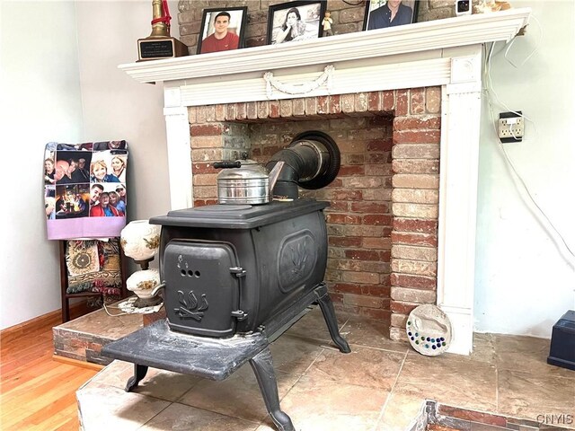 room details with a wood stove and wood-type flooring