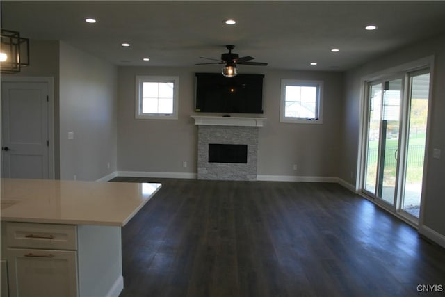 unfurnished living room with plenty of natural light, dark wood-type flooring, and a fireplace