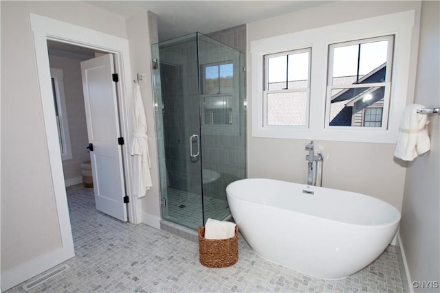 full bathroom featuring tile patterned floors, baseboards, a soaking tub, and a stall shower