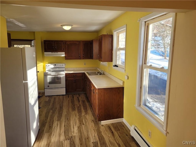 kitchen with dark wood-type flooring, sink, a baseboard radiator, and white appliances