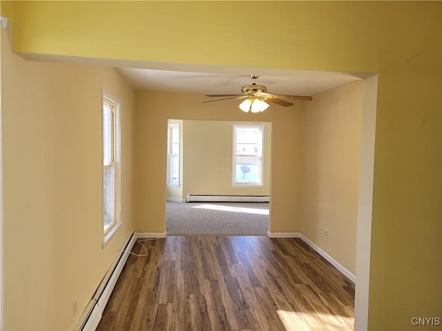 spare room with ceiling fan, dark hardwood / wood-style flooring, and a baseboard heating unit