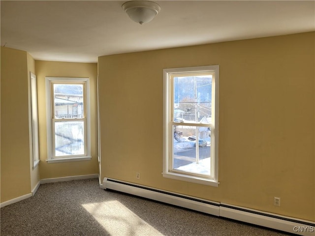 carpeted empty room with baseboard heating and a healthy amount of sunlight