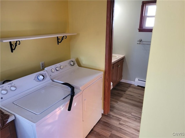 washroom with washer and dryer, light hardwood / wood-style floors, and baseboard heating