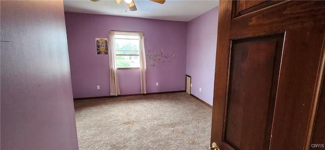 carpeted spare room featuring ceiling fan