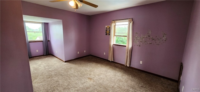 empty room featuring ceiling fan and light colored carpet