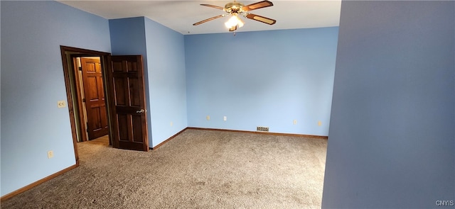 carpeted spare room featuring ceiling fan