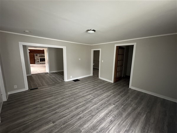 empty room with crown molding and dark hardwood / wood-style floors