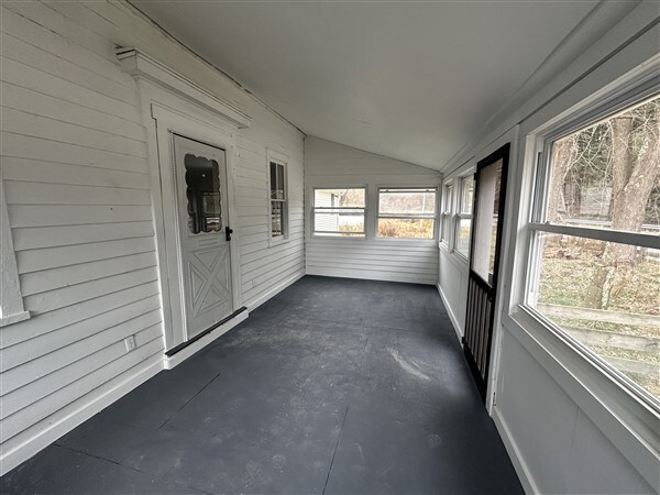 unfurnished sunroom with lofted ceiling