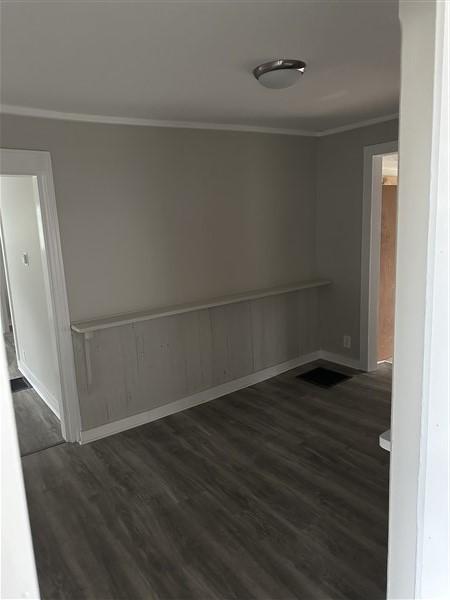 unfurnished room with crown molding and dark hardwood / wood-style floors