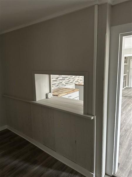 interior space featuring dark hardwood / wood-style flooring and crown molding