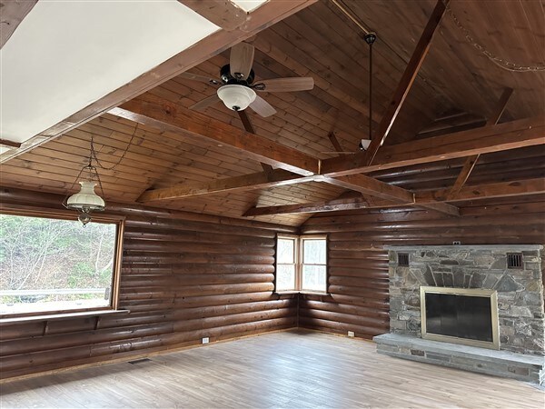 unfurnished living room with wooden ceiling, a healthy amount of sunlight, and light wood-type flooring