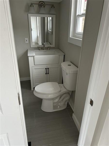 bathroom featuring vanity, wood-type flooring, and toilet