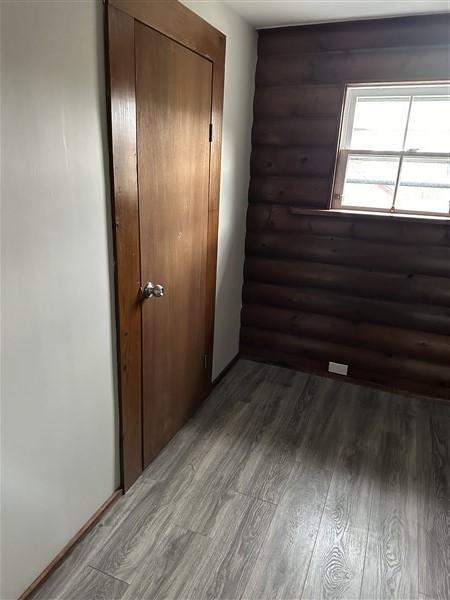 interior space with dark hardwood / wood-style flooring and rustic walls