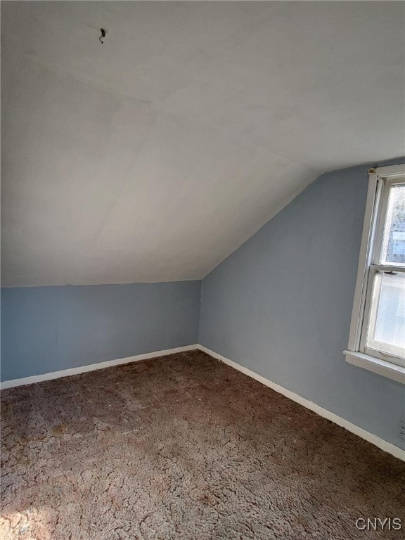 bonus room with carpet flooring and vaulted ceiling