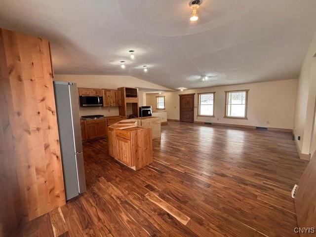 kitchen featuring lofted ceiling, dark wood-style flooring, baseboards, open floor plan, and appliances with stainless steel finishes