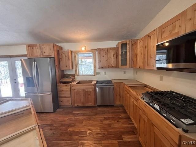 kitchen featuring stainless steel fridge, dishwashing machine, glass insert cabinets, dark wood-style flooring, and french doors