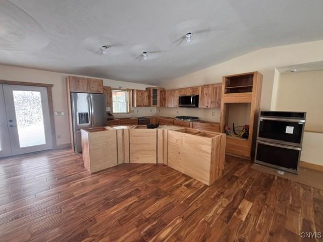 kitchen with stainless steel appliances, dark wood-type flooring, vaulted ceiling, a center island, and open shelves