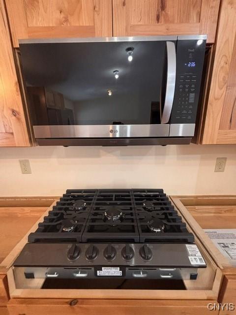 details featuring light countertops, appliances with stainless steel finishes, and light brown cabinets