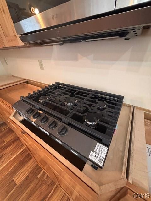 room details with black cooktop and wood finished floors