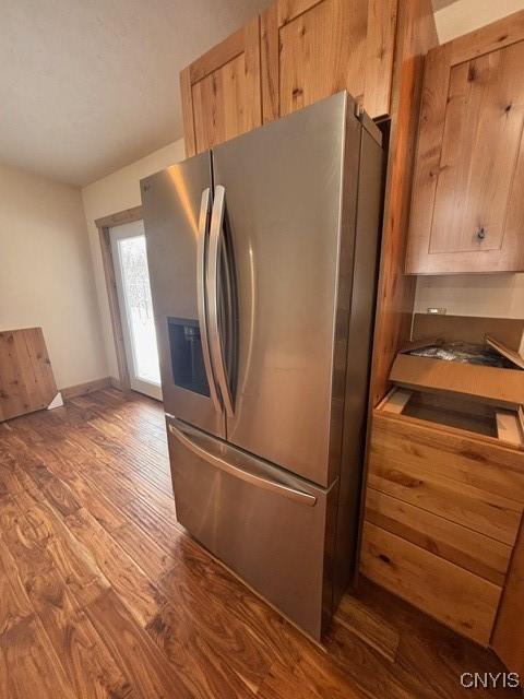 kitchen with dark wood-style floors, baseboards, and stainless steel fridge with ice dispenser